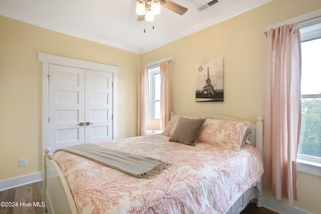 bedroom with dark hardwood / wood-style floors, a closet, ornamental molding, and ceiling fan