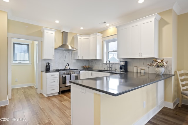 304 Birmingham Ave Unit 2, Carolina Beach, NC 28428 - kitchen with wall chimney exhaust hood, high end stainless steel range oven, dark countertops, a sink, and recessed lighting