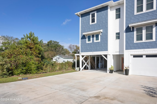 view of side of property with a garage and a carport