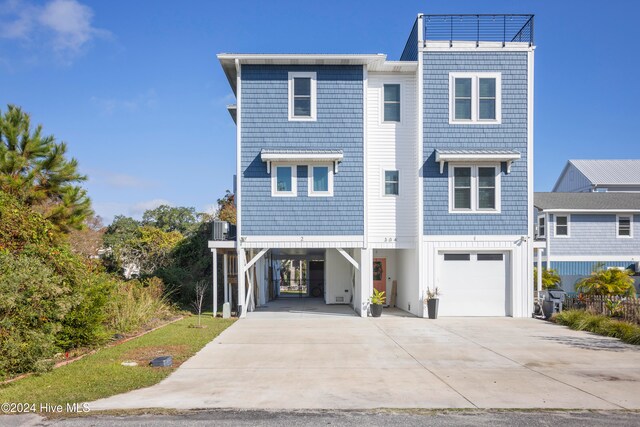 view of front of house with a carport, central AC unit, and a garage