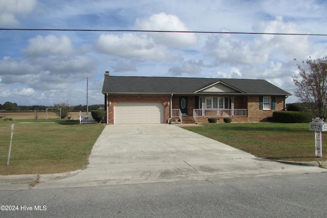 single story home with covered porch, a garage, and a front lawn