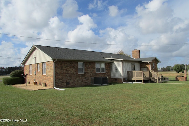 rear view of property featuring central AC, a yard, and a deck