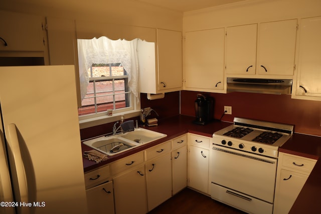 kitchen featuring refrigerator, white range oven, white cabinetry, and sink