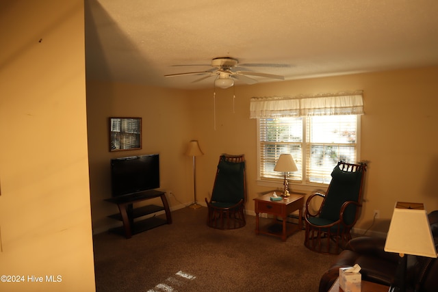 living area featuring carpet, a textured ceiling, and ceiling fan