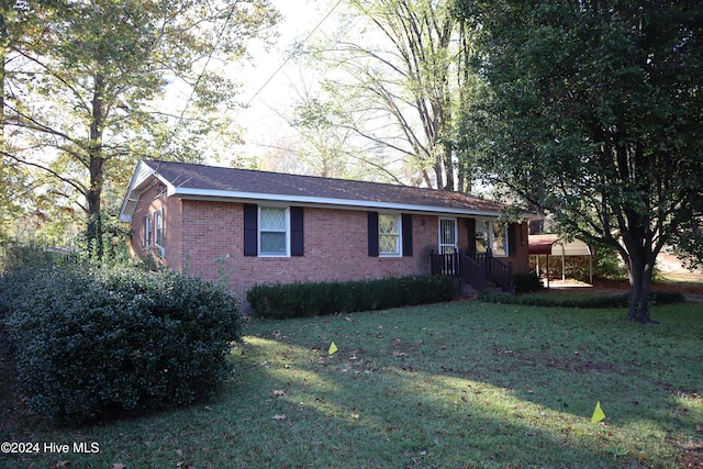 view of front of property featuring a front lawn and a carport