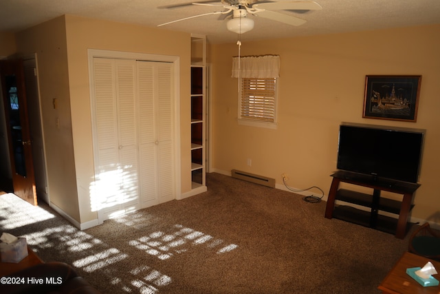 unfurnished bedroom featuring a textured ceiling, ceiling fan, a baseboard heating unit, carpet floors, and a closet