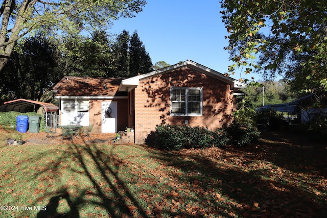 view of front of property featuring a carport and a front lawn