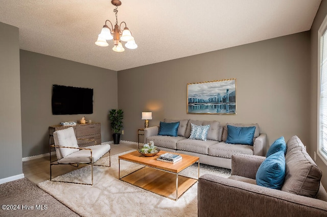 carpeted living room with an inviting chandelier and a textured ceiling