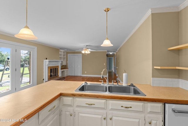 kitchen with white cabinets, hardwood / wood-style flooring, hanging light fixtures, and sink