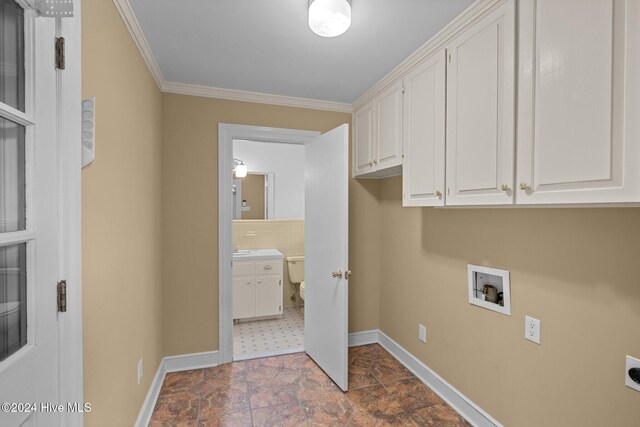 washroom featuring hookup for a washing machine, electric dryer hookup, cabinets, and crown molding