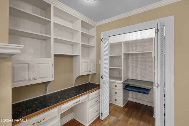 interior space featuring ornamental molding, dark hardwood / wood-style flooring, and built in desk