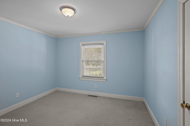 carpeted empty room featuring crown molding