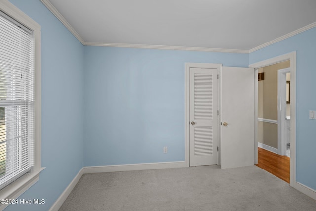 unfurnished bedroom featuring light colored carpet and crown molding