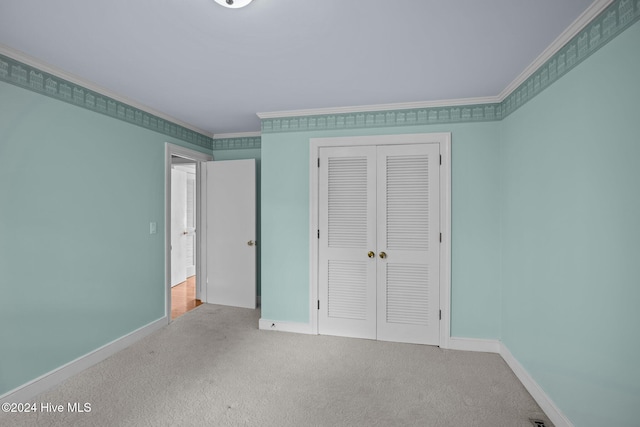 unfurnished bedroom with a closet, crown molding, and carpet floors