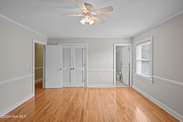 unfurnished bedroom featuring light hardwood / wood-style floors, ornamental molding, ensuite bathroom, ceiling fan, and a closet