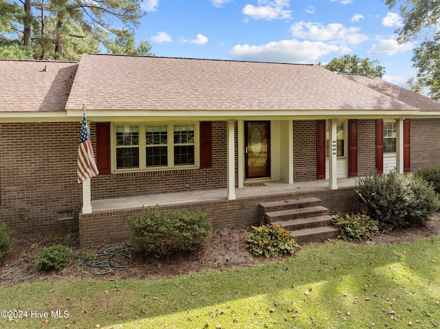 ranch-style home featuring a porch and a front lawn