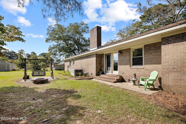 view of yard featuring central air condition unit and a fire pit