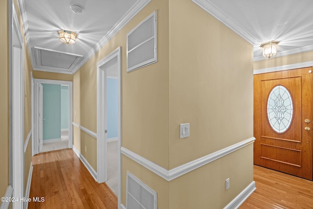 foyer with ornamental molding and light hardwood / wood-style floors