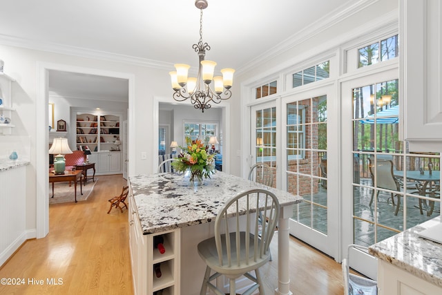 dining room with ornamental molding, light hardwood / wood-style flooring, and a healthy amount of sunlight