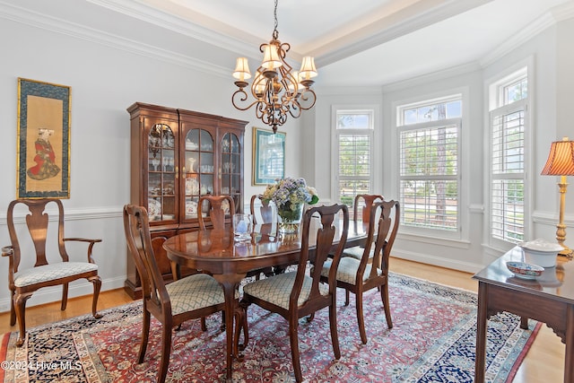 dining space featuring a notable chandelier, light wood-type flooring, and crown molding