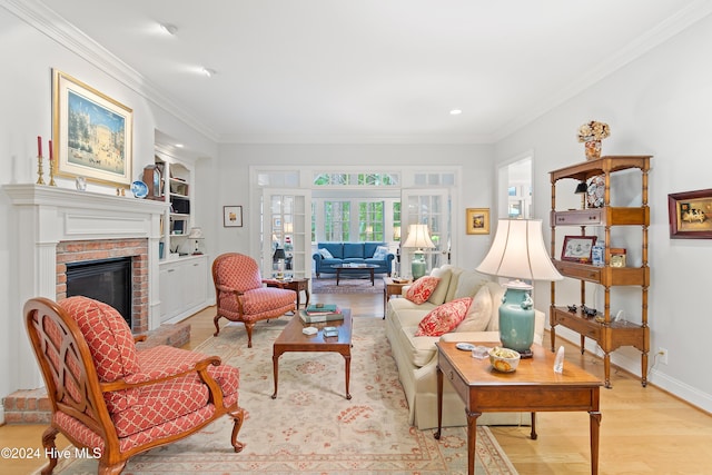 living room featuring crown molding, a fireplace, and light hardwood / wood-style floors