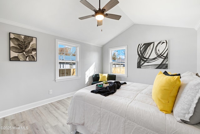 bedroom featuring multiple windows, ceiling fan, vaulted ceiling, and light wood-type flooring