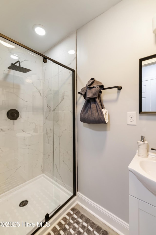 bathroom with a shower with door and vanity