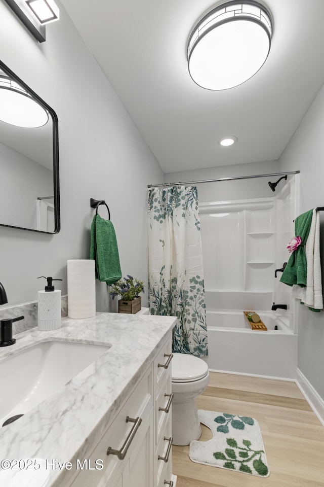 full bathroom featuring toilet, hardwood / wood-style floors, vanity, and shower / tub combo with curtain