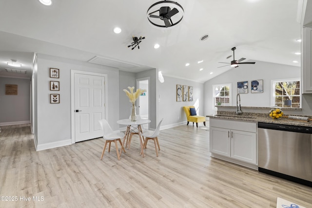 kitchen with white cabinetry, sink, ceiling fan, stainless steel dishwasher, and dark stone countertops