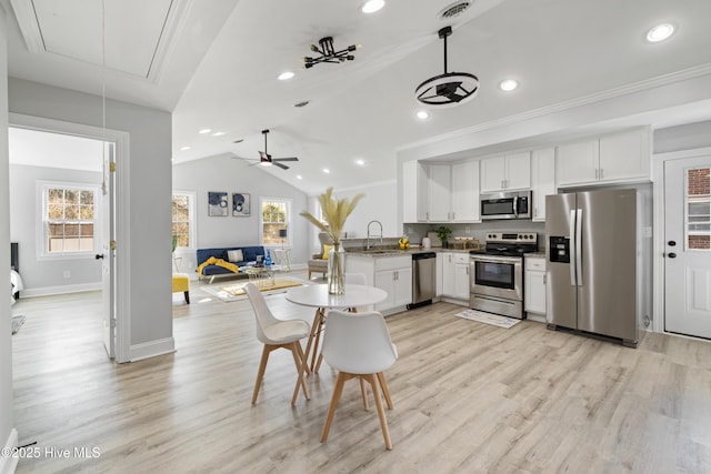 kitchen with white cabinetry, ceiling fan, light hardwood / wood-style floors, pendant lighting, and appliances with stainless steel finishes