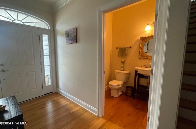 foyer with crown molding and hardwood / wood-style flooring