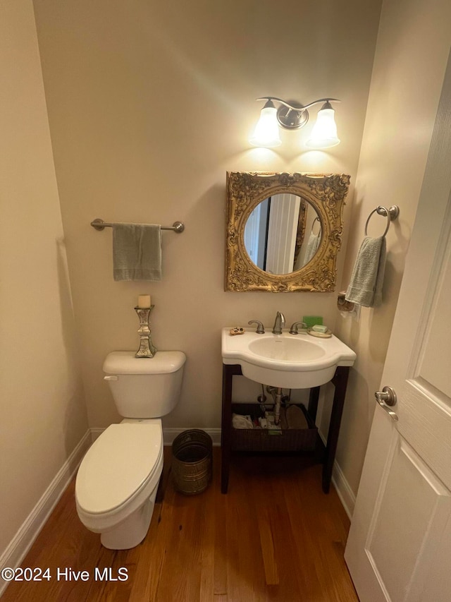 bathroom with hardwood / wood-style floors and toilet