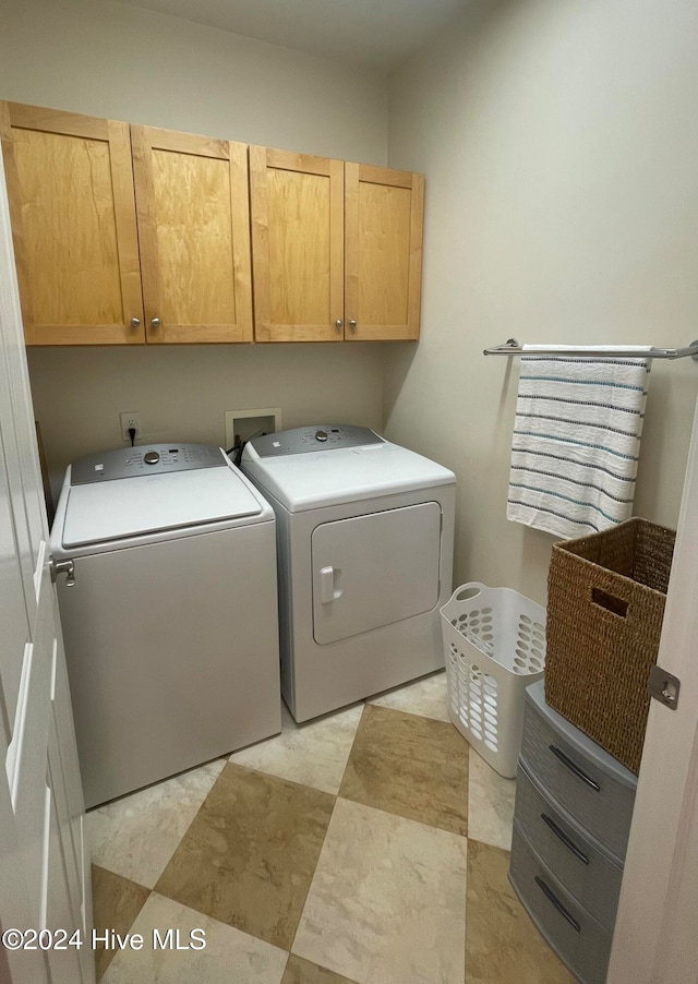 washroom featuring separate washer and dryer and cabinets