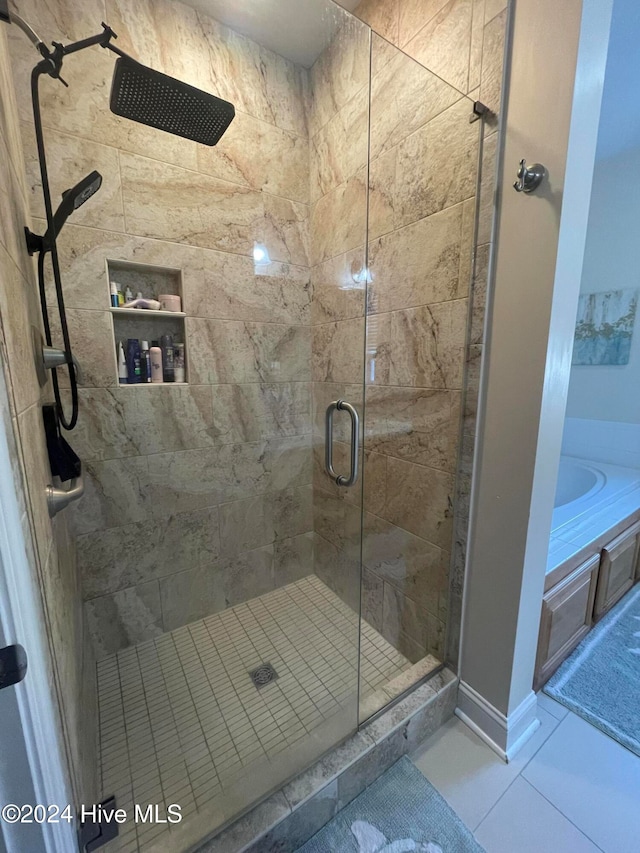 bathroom with tile patterned floors and a shower with door