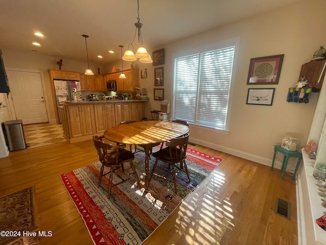 dining area featuring light hardwood / wood-style flooring and a notable chandelier