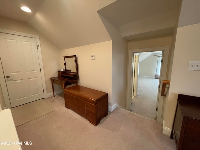 corridor featuring light carpet and vaulted ceiling