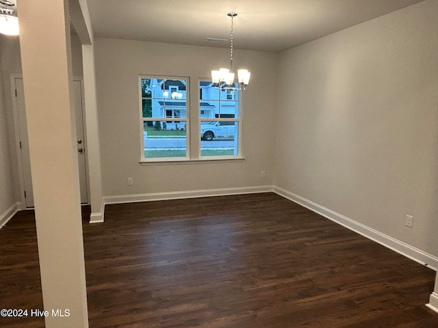 unfurnished dining area with dark wood-type flooring and an inviting chandelier