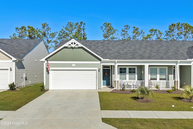 single story home with covered porch, a garage, and a front lawn