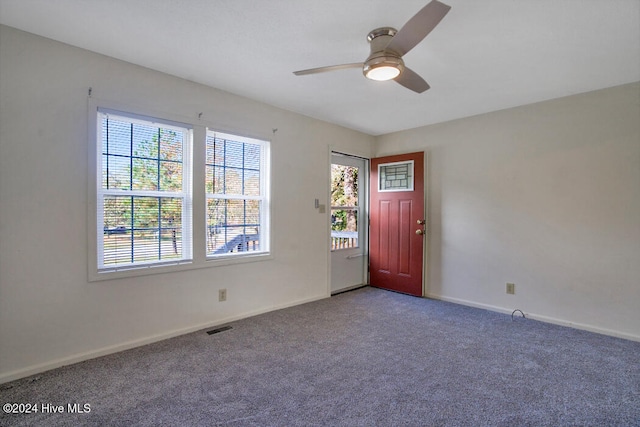 carpeted spare room with ceiling fan