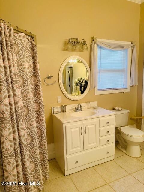 bathroom with toilet, vanity, and tile patterned flooring