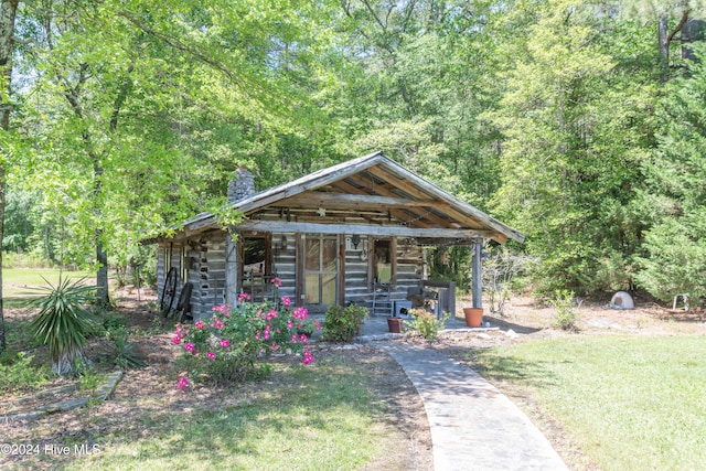 log cabin with a front lawn and an outbuilding