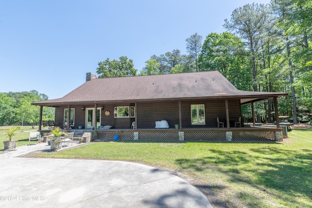 view of front facade featuring a front lawn, covered porch, and a patio