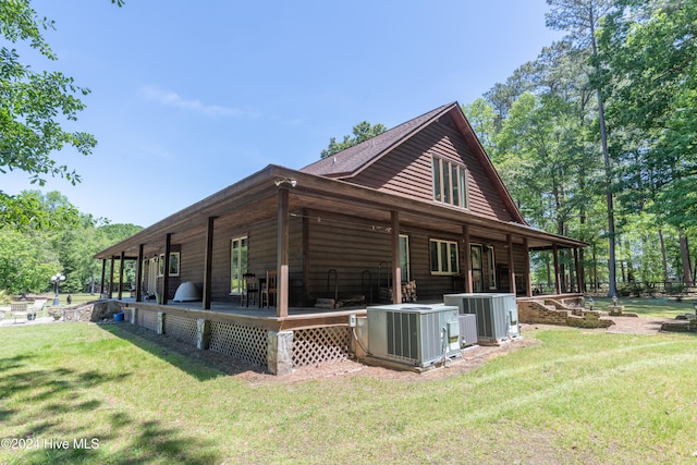 view of side of home with central AC unit and a yard