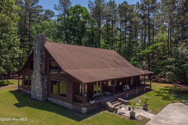 rear view of property with a lawn and covered porch