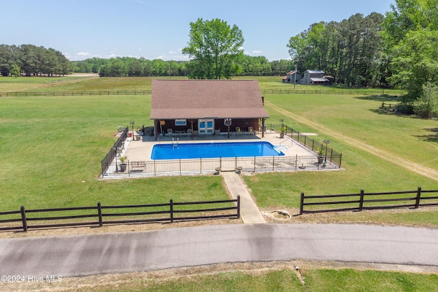 view of pool featuring a rural view and a yard