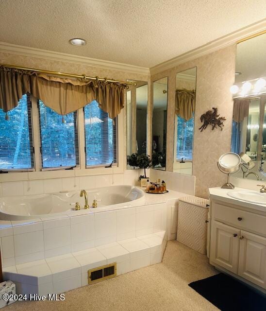 bathroom featuring vanity, tiled bath, a textured ceiling, and crown molding