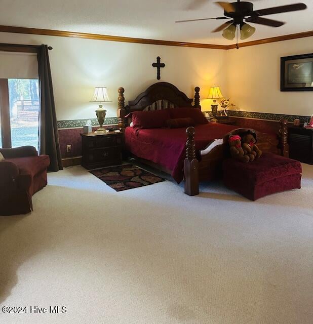 carpeted bedroom with ceiling fan and ornamental molding