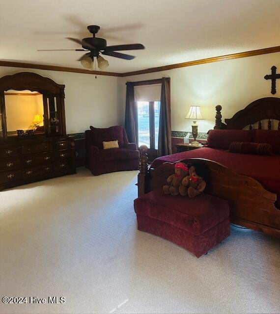 bedroom featuring ceiling fan, ornamental molding, and light colored carpet