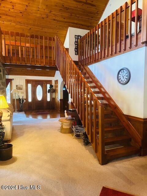 stairs with wood ceiling, carpet flooring, and wooden walls