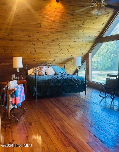 bedroom with wooden walls, hardwood / wood-style floors, and wooden ceiling